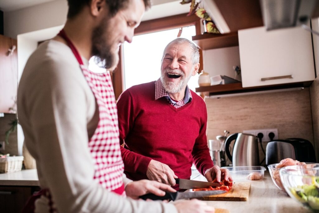 Älterer und jüngerer Mann kochen zusammen